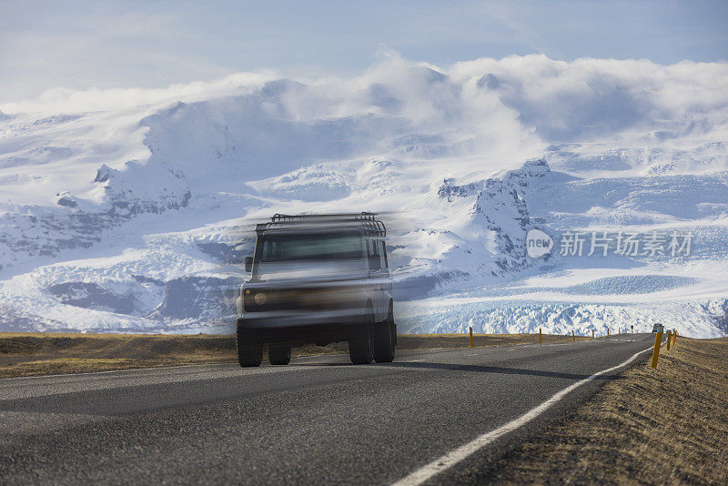 car on the road in Iceland with the mountains around the Vatnajökull glacier in the background